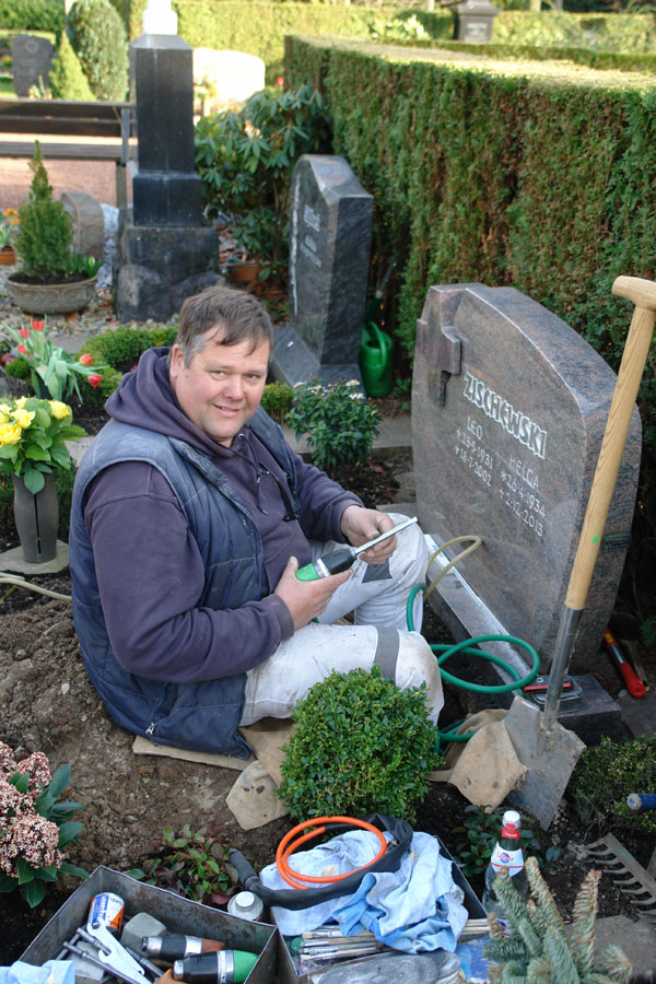 Steinmetz Roland Trogemann bei einer Nachbeschriftung auf dem Friedhof